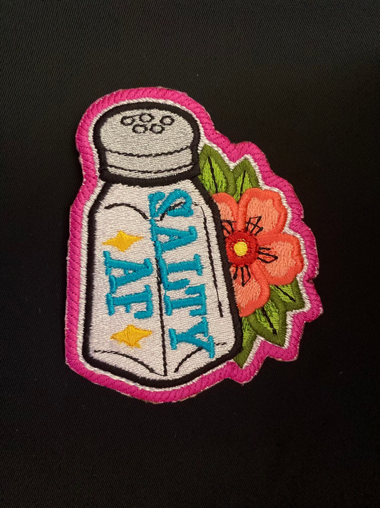 Embroidered patch of a salt shaker with flowers on a black background